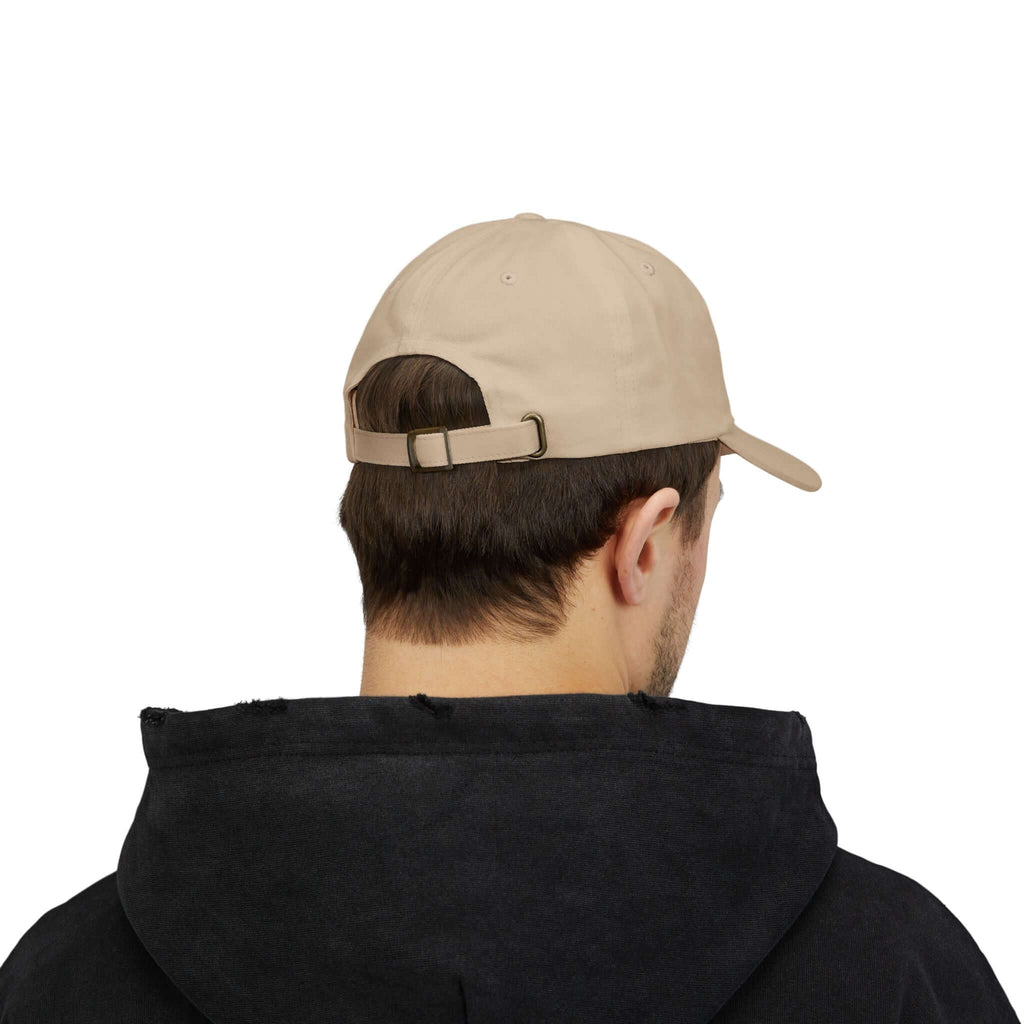 Back view of a man wearing a beige Classic Cap from TeamSharkcage, showing adjustable strap detail.
