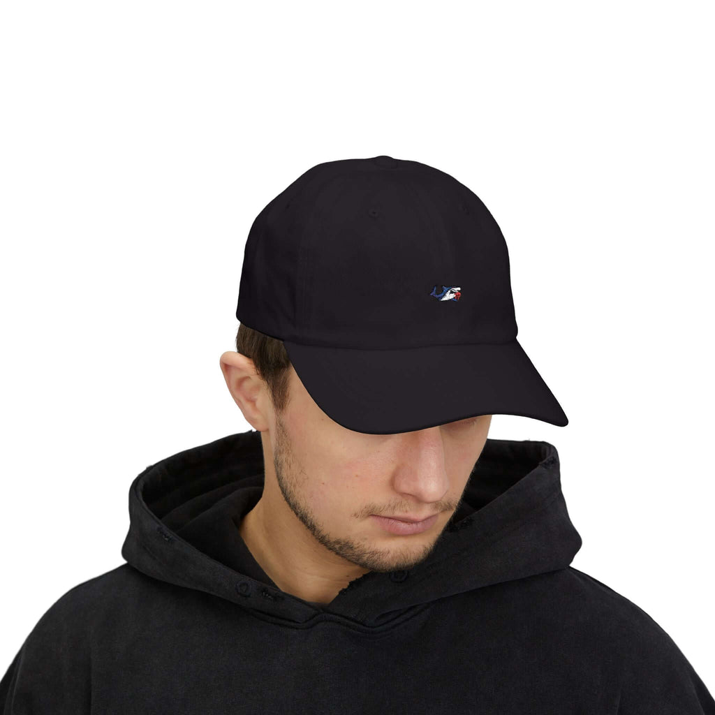 Close-up of a man wearing a black TeamSharkcage Classic Cap with white embroidered logo, styled for sporty and casual everyday wear.